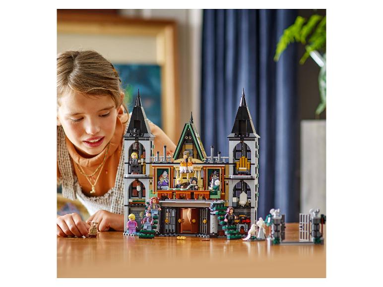 Ein Mädchen spielt mit einem LEGO Harry Potter Bausatz, einem detaillierten Schloss.