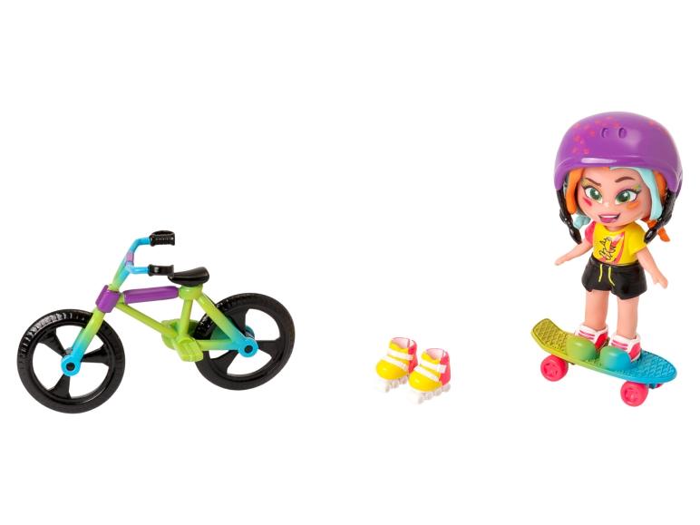 Eine Puppe mit Helm auf einem Skateboard, ein Fahrrad und ein Paar Rollschuhe.