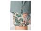 Grünes T-Shirt und gemusterte Shorts mit tropischem Blatt- und Blumenmotiv.
