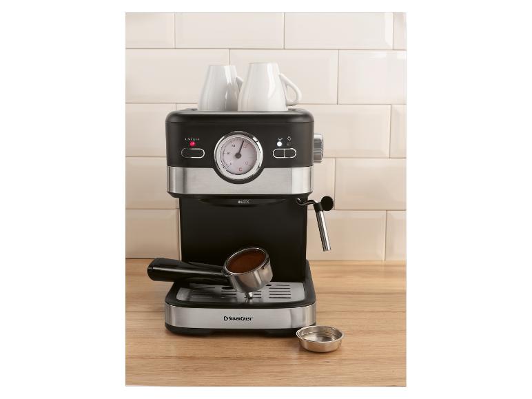 Espressomaschine mit zwei Tassen und Siebträger mit Kaffee auf einer Holztheke.