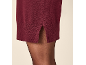 Nahaufnahme eines burgunderroten Strickkleides mit Seitenschlitz, getragen mit transparenten schwarzen Strumpfhosen.