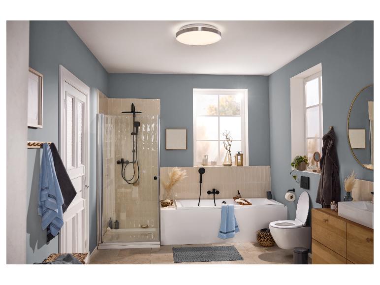 Modernes Badezimmer mit Dusche, Badewanne, Toilette und Holzwaschtisch, mit blau-grauen Wänden.