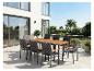 Garten-Essgruppe mit Holztisch und Korbstühlen auf einer modernen Terrasse.