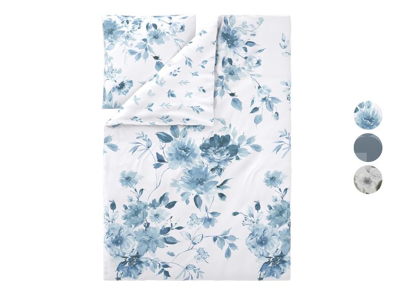 Weiße Bettwäsche mit blauem Blumenmuster, inklusive Kissen und Bettbezug.