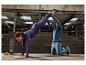 Eine Frau in CRIVIT Sportschuhen macht einen Handstand mit Hilfe eines Partners.