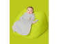 Baby in hellblauem Schlafsack mit Bärenmuster auf einem lindgrünen Sitzsack.