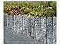 Steinmauer mit farbenfrohem Blumenbeet und Terrassenplatten.