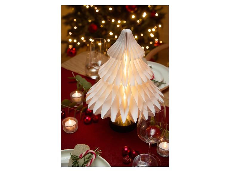 Weihnachtstisch dekoriert mit einem beleuchteten Papierbaum, Kerzen und roten Ornamenten.