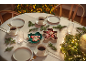 Weihnachtstisch mit Kaffeetassen, Tellern, Lebkuchen und Tannenzweigen.