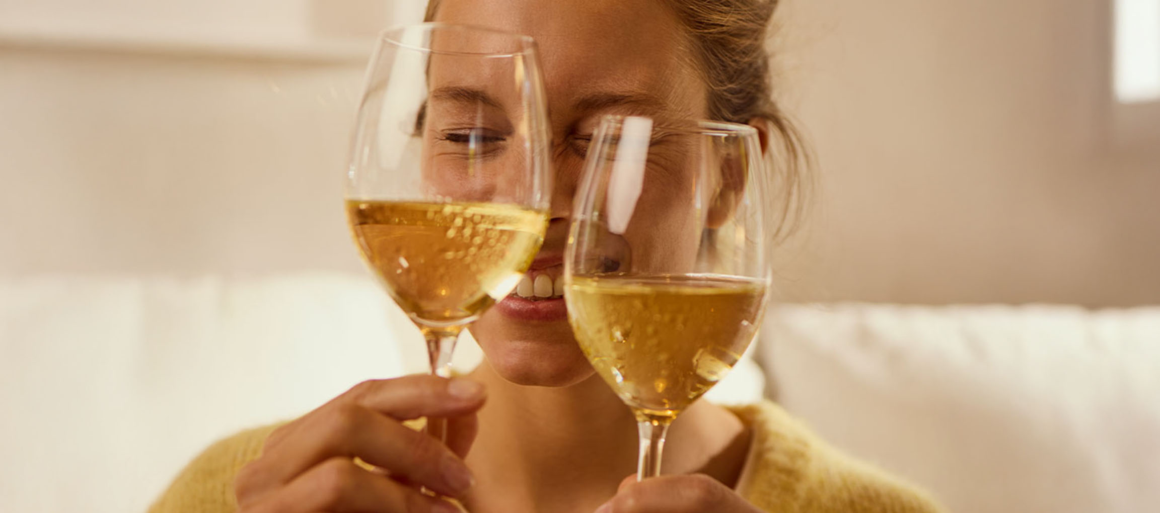 Lächelnde Frau hält zwei Gläser Sekt