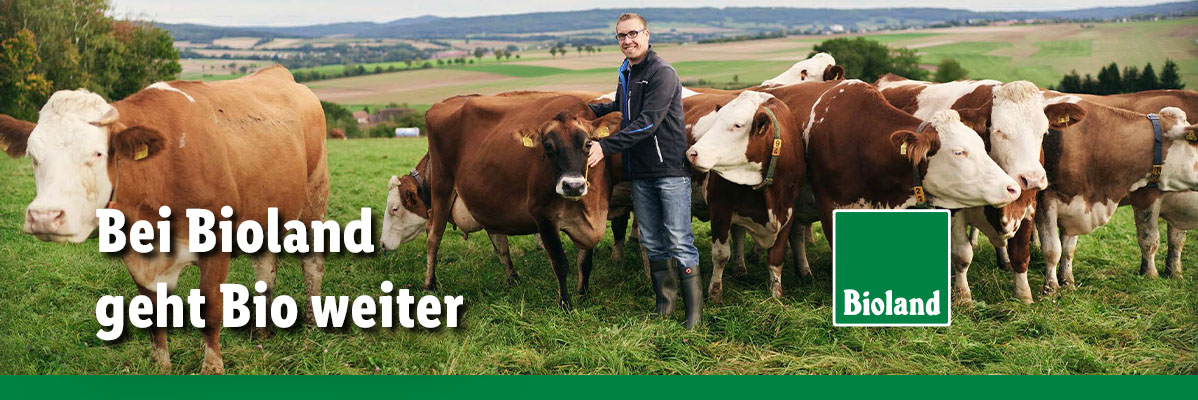 Bei Bioland geht Bio weiter. Bioland-Bauer mit seinen Kühen auf der Weide.