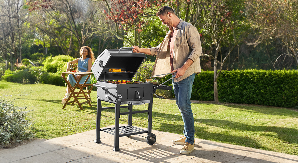 Mann grillt im Garten.