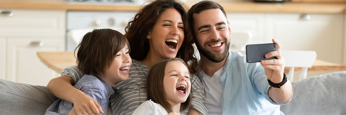 Eine glückliche Familie macht ein Selfie mit ihrem Smartphone.