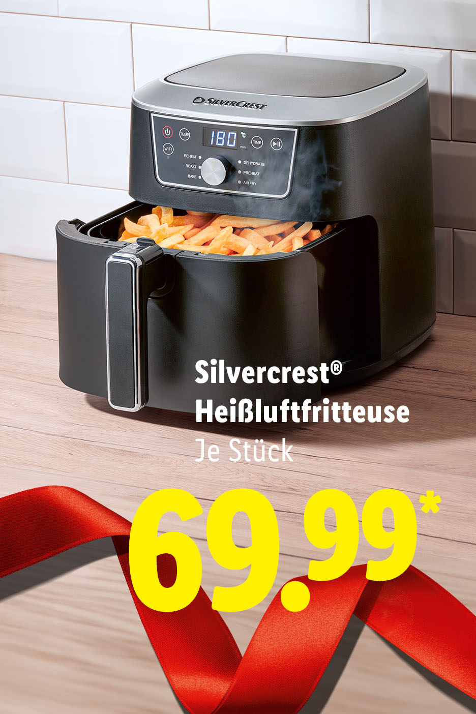 SilverCrest Heißluftfritteuse mit Pommes frites und rotem Band auf Holztisch