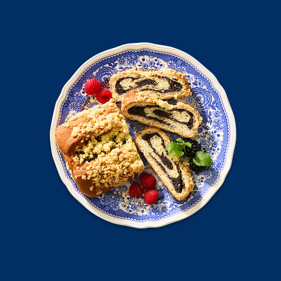 Mohnkuchen mit Beeren auf einem blau-weißen Teller