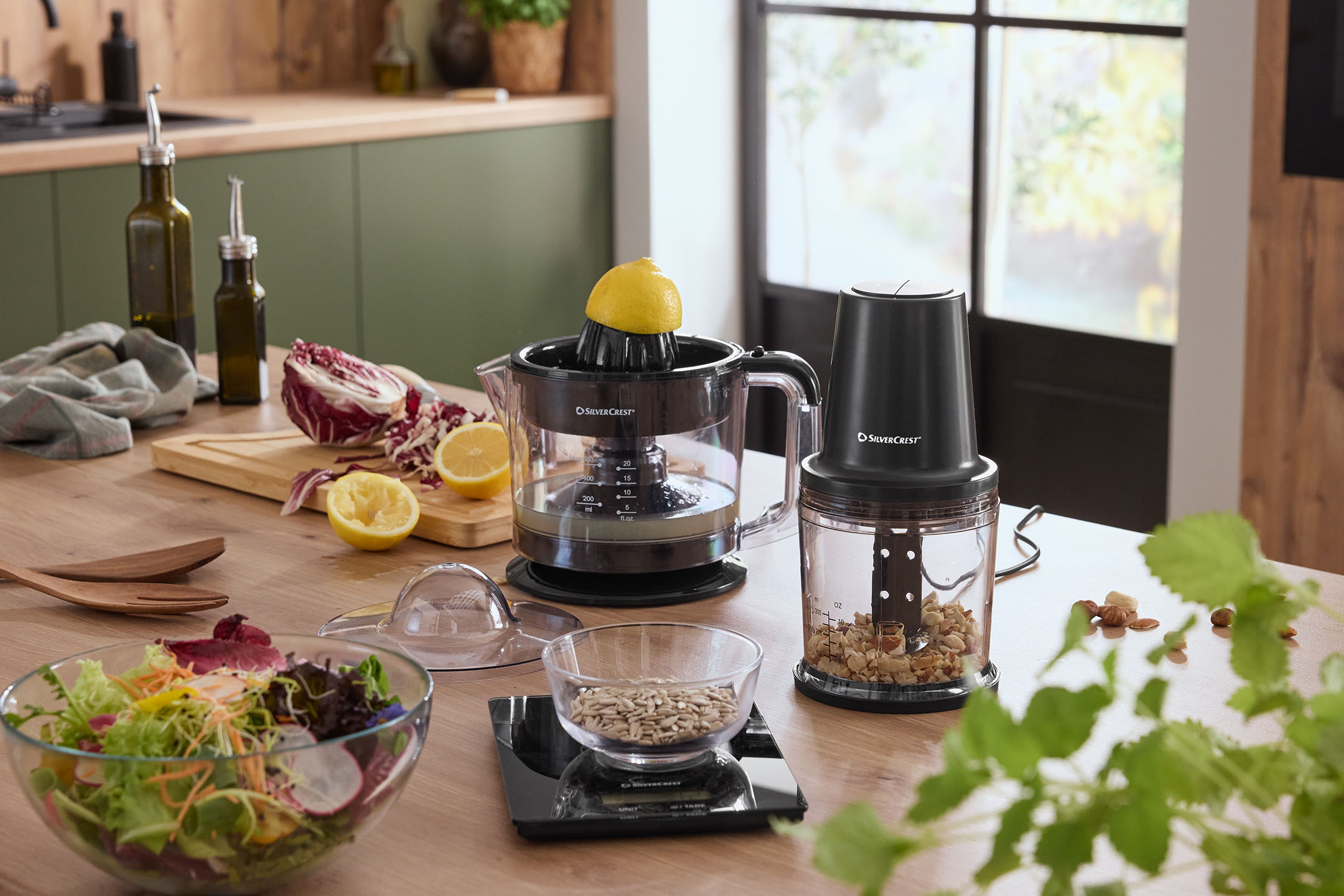 SilverCrest Entsafter und Zerkleinerer in einer Küche mit Salat und Zutaten