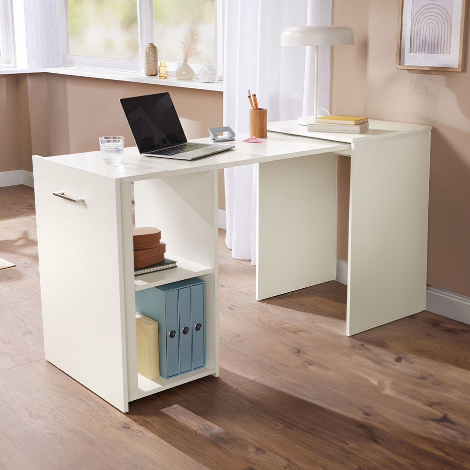 Weißer Schreibtisch mit Laptop, Lampe und Ablagefächern in einem hellen Raum