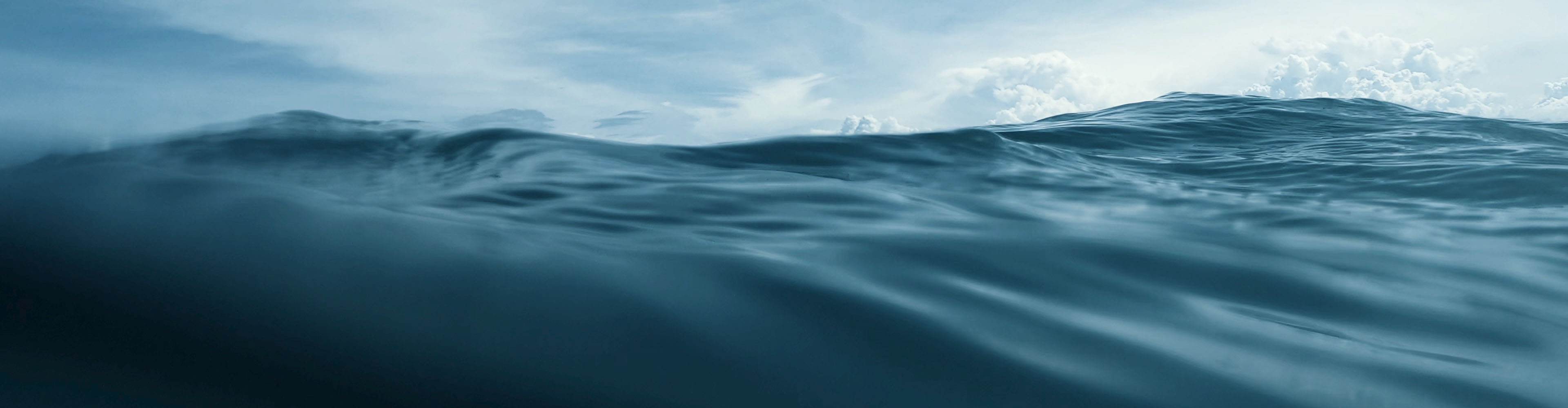 Unterwasseraufnahme des Meeres mit Wellen und bewölktem Himmel