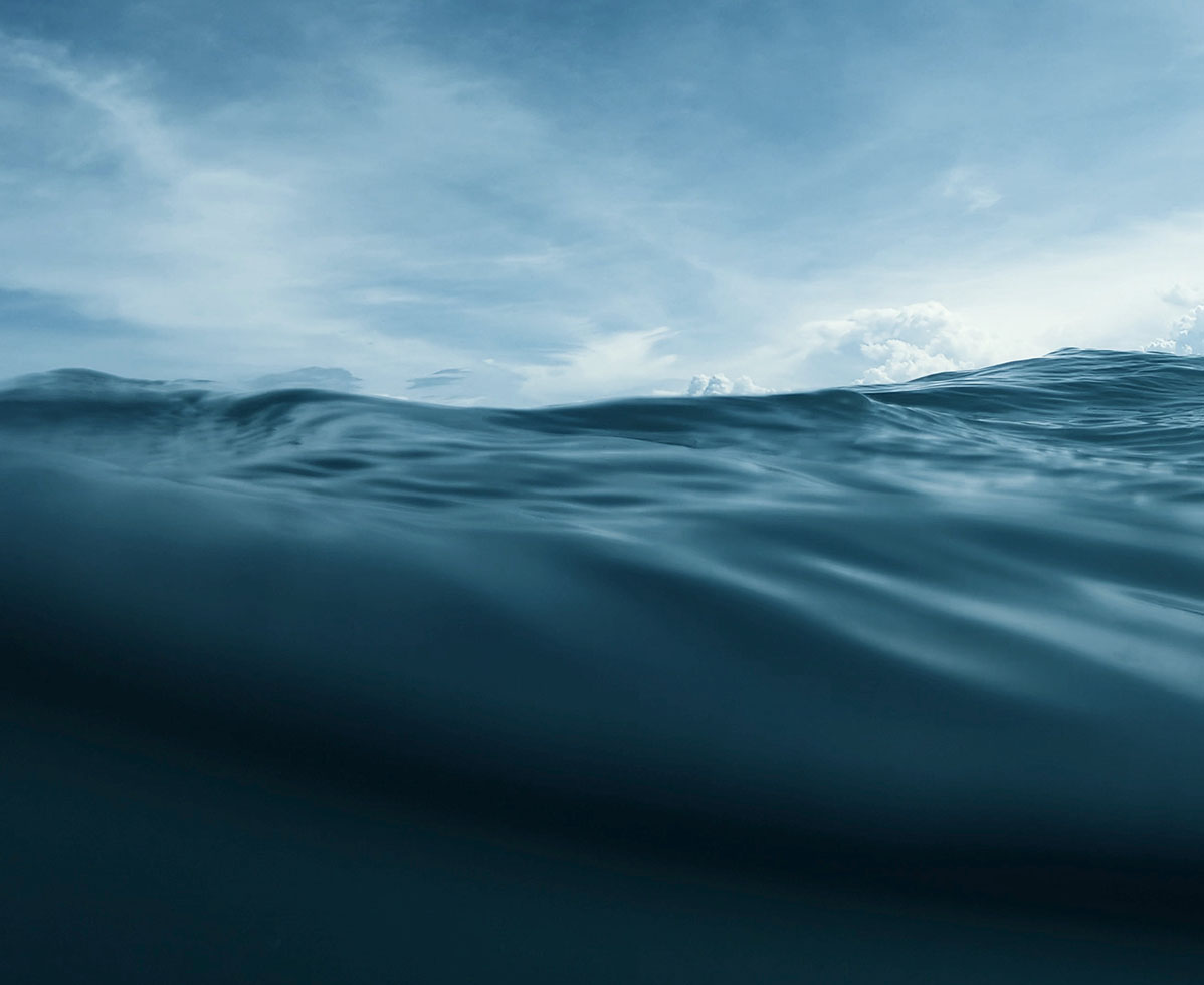 Unterwasseraufnahme des Meeres mit Wellen und bewölktem Himmel