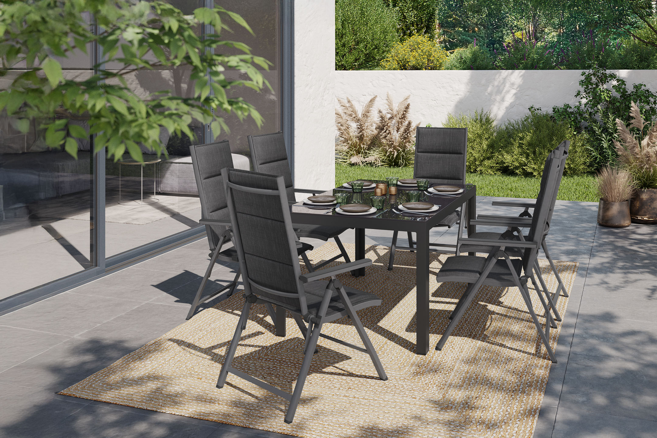 Gartentisch mit sechs Stühlen auf einer Terrasse mit Pflanzen und Gartenblick.