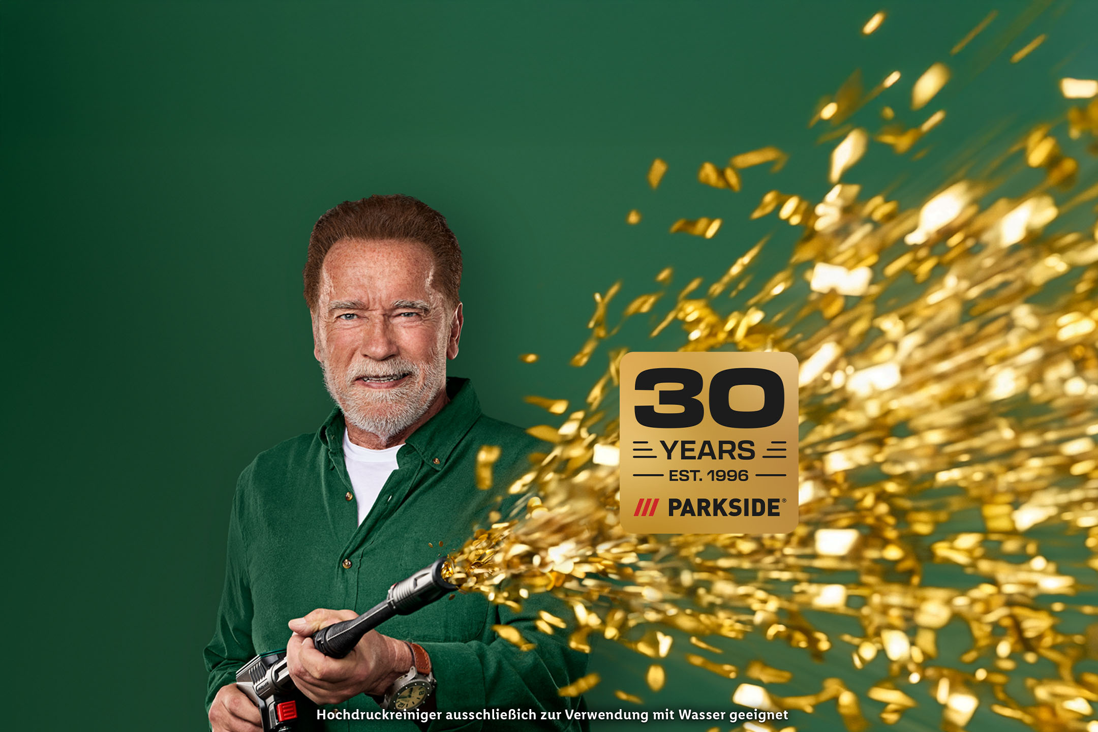 Arnold Schwarzenegger mit einem Hochdruckreiniger und dem Logo „30 Jahre Parkside“. Hochdruckreiniger ausschließlich zur Verwendung mit Wasser geeignet