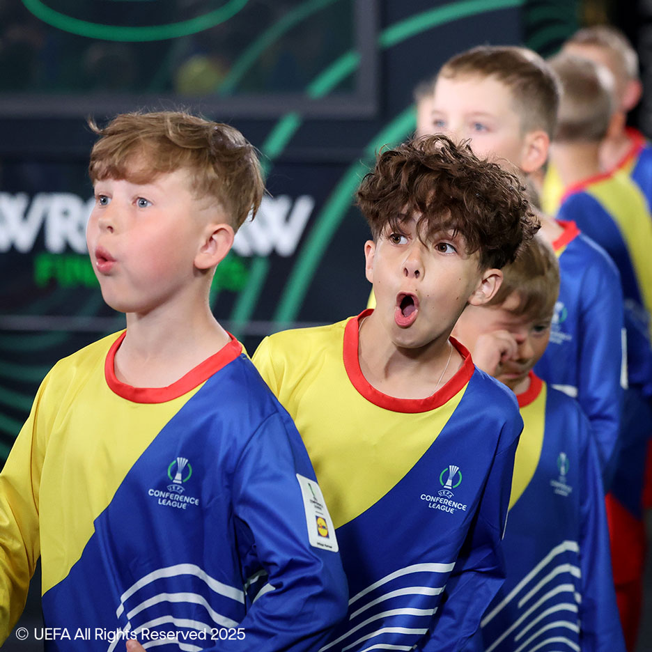 Zwei Jungen in gelb-blauen Trikots mit Fußballmotiven, sehen überrascht aus.