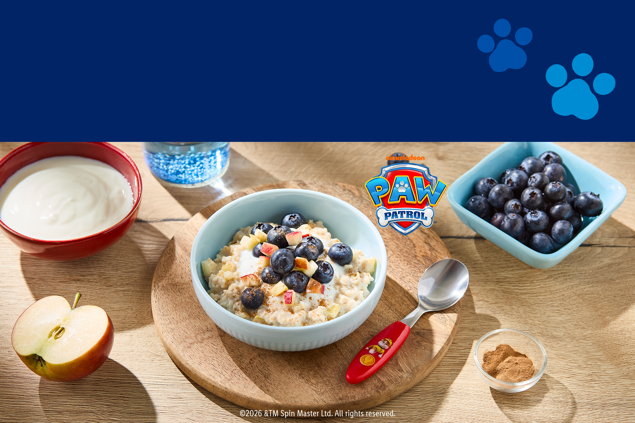 Haferflocken mit Heidelbeeren und Apfel, Joghurt, mit Hundepfoten-Logo.