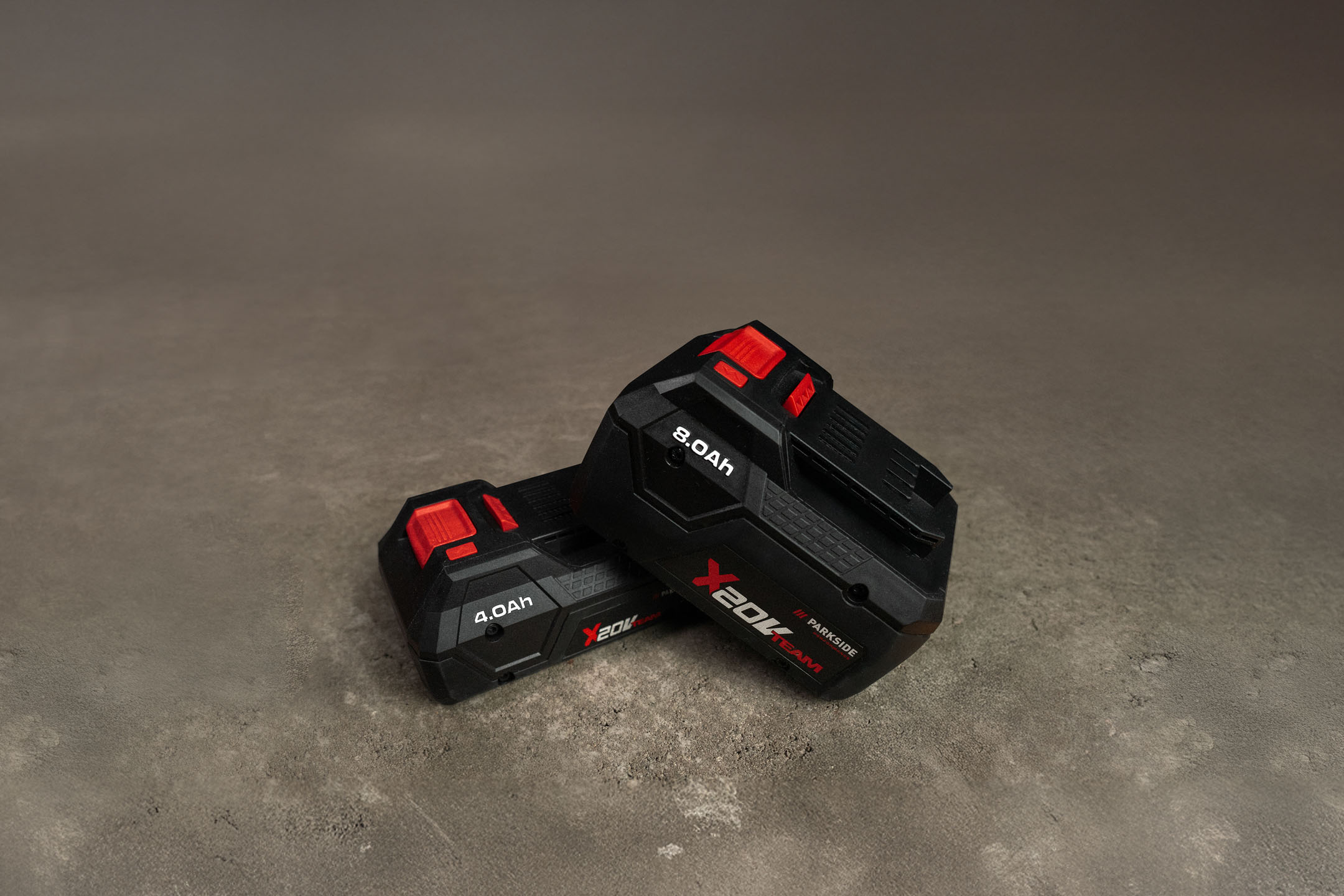 Zwei Parkside X 20V Team Akkus, ein 4.0Ah und ein 8.0Ah, auf grauem Hintergrund.
