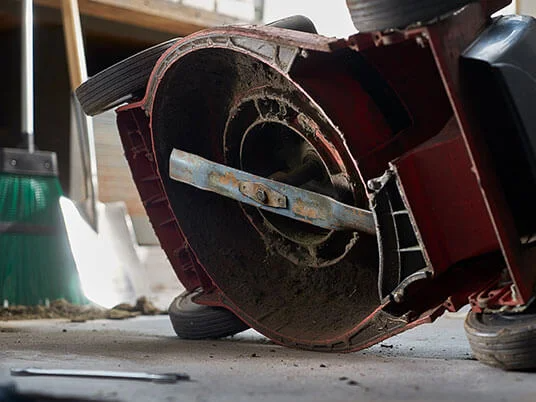 Schmutziger Rasenmäher auf dem Kopf, Klinge sichtbar