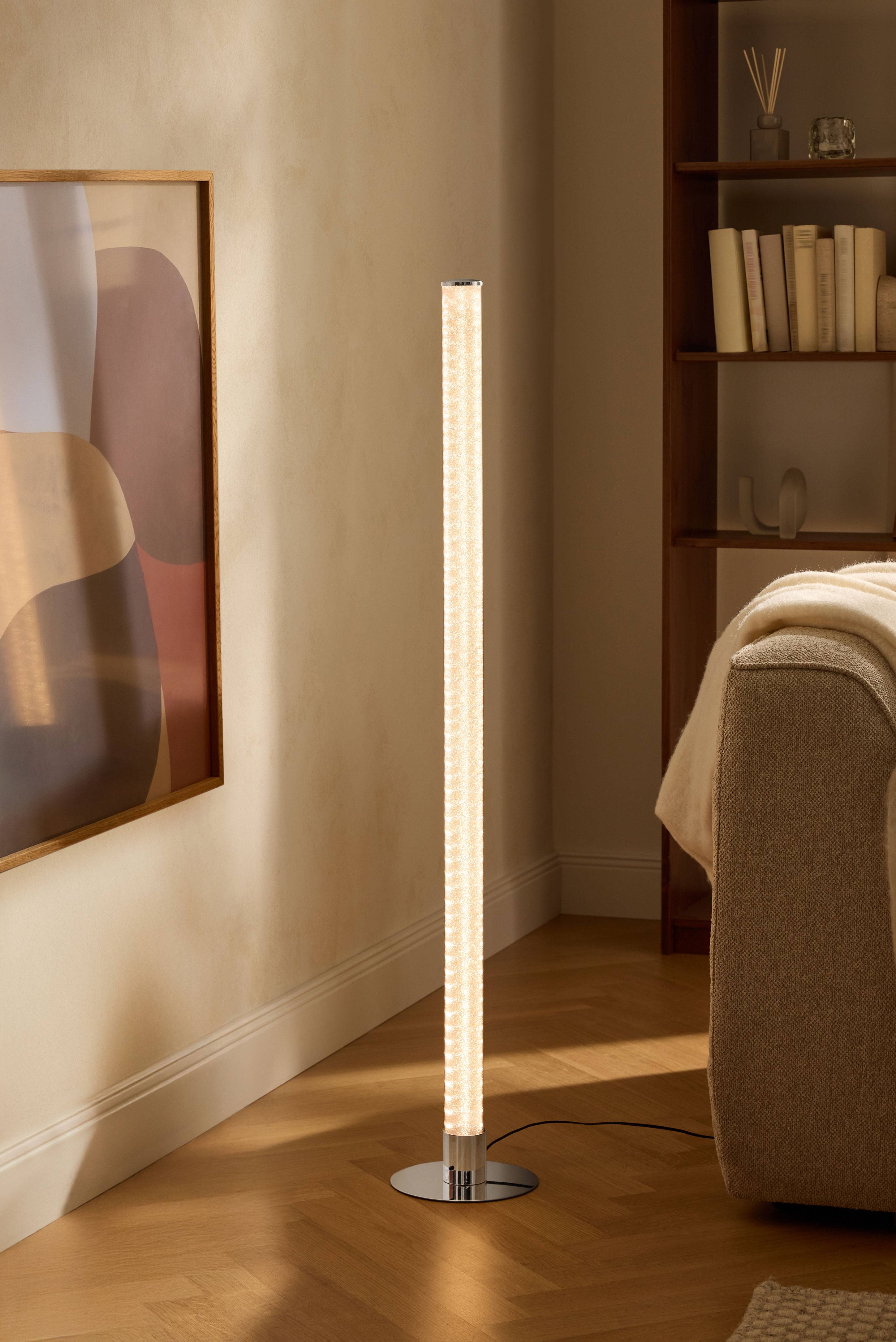 Moderne Stehlampe im Wohnzimmer mit Bücherregal und Sofa.