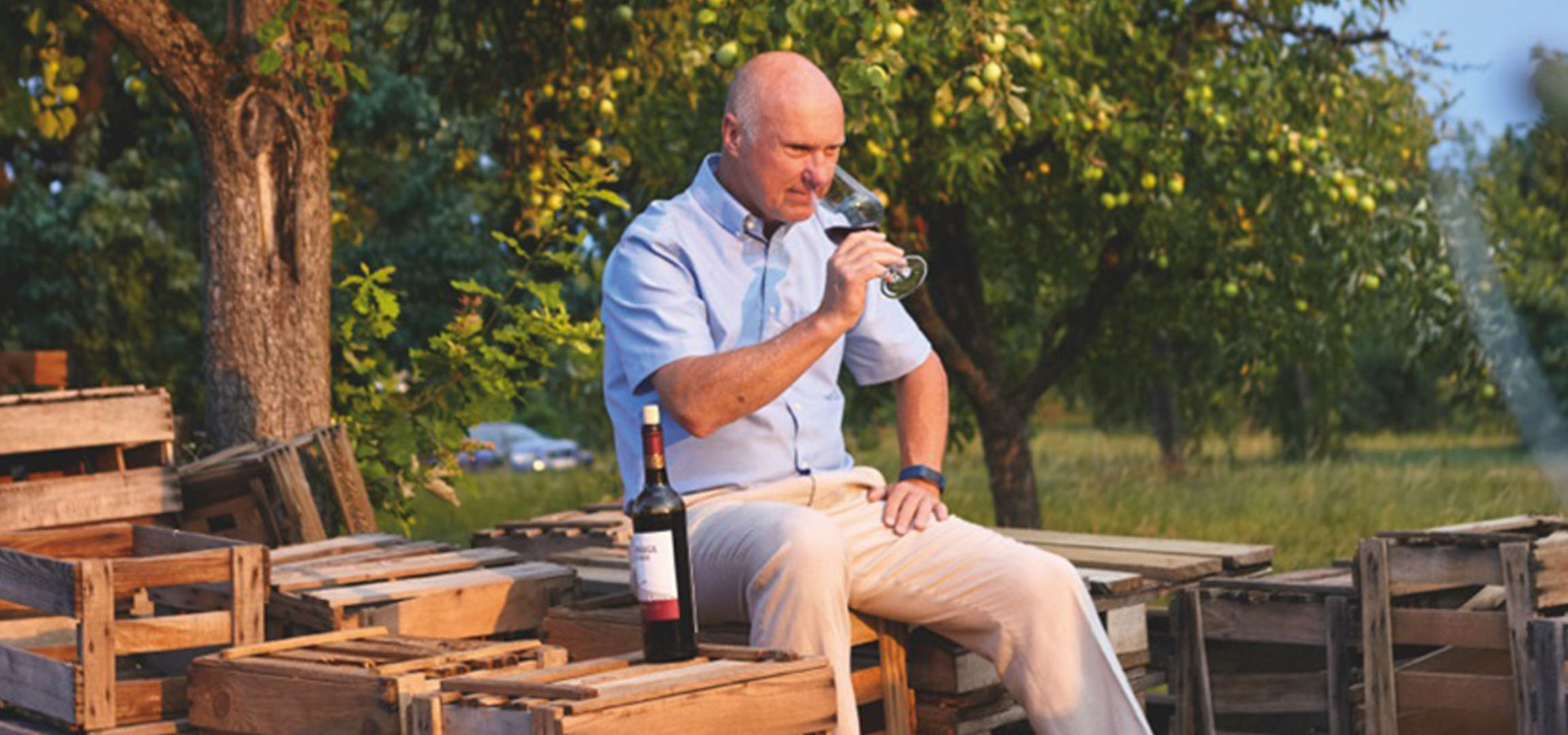 Mann genießt Wein in einem Weinberg.