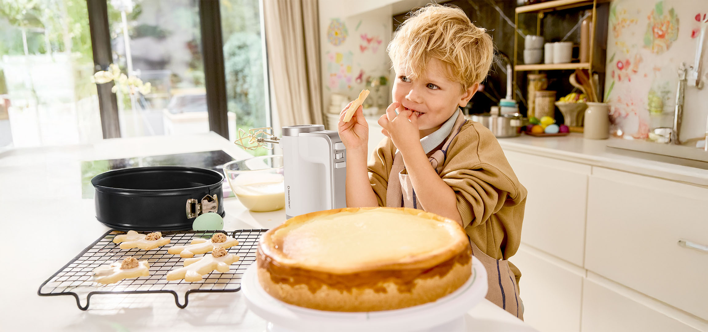 Junge probiert Teig beim Backen von Kuchen und Keksen in der Küche.