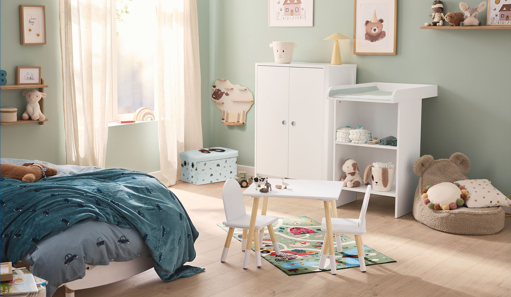Kinderzimmer mit Bett, Wickeltisch, Kleiderschrank und Spieltisch mit Stühlen.