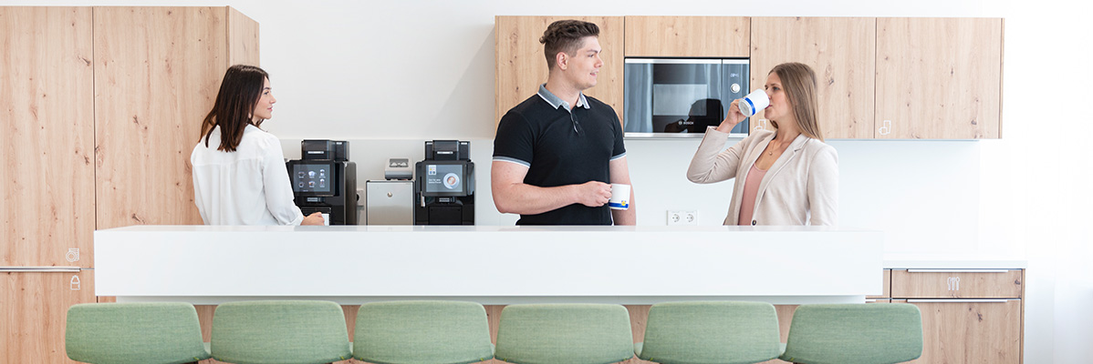 Kaffeevollautomaten und Personen bei einer Kaffeepause.