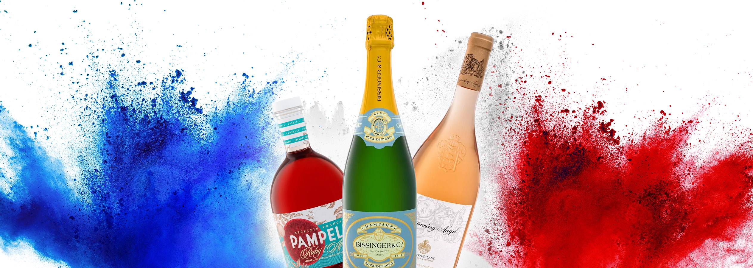 Drei Flaschen Wein und Champagner, darunter BISSINGER & CO. und Whispering Angel, vor blauem und rotem Farbpulver.