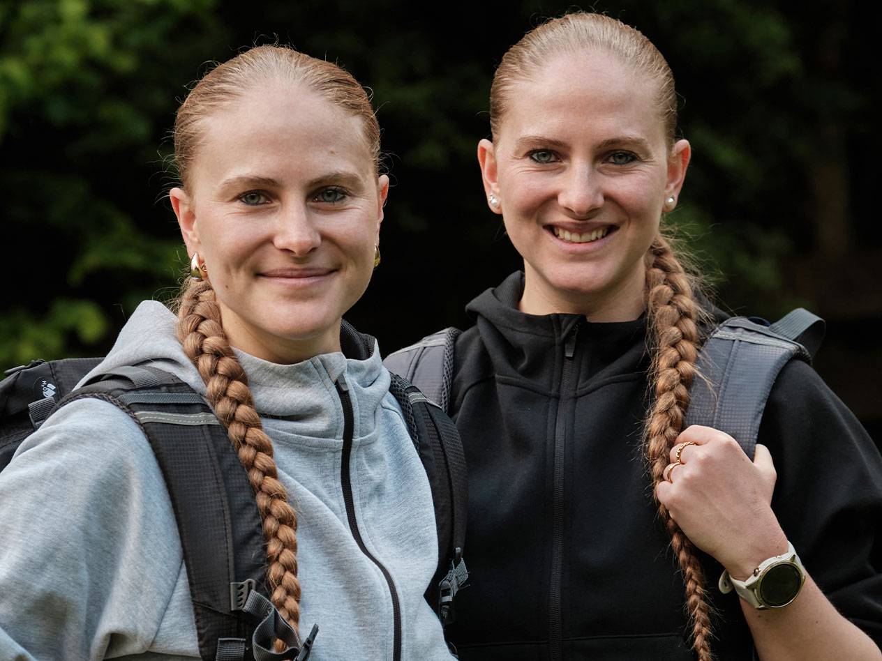 Zwei Frauen mit Rucksäcken stehen zusammen.